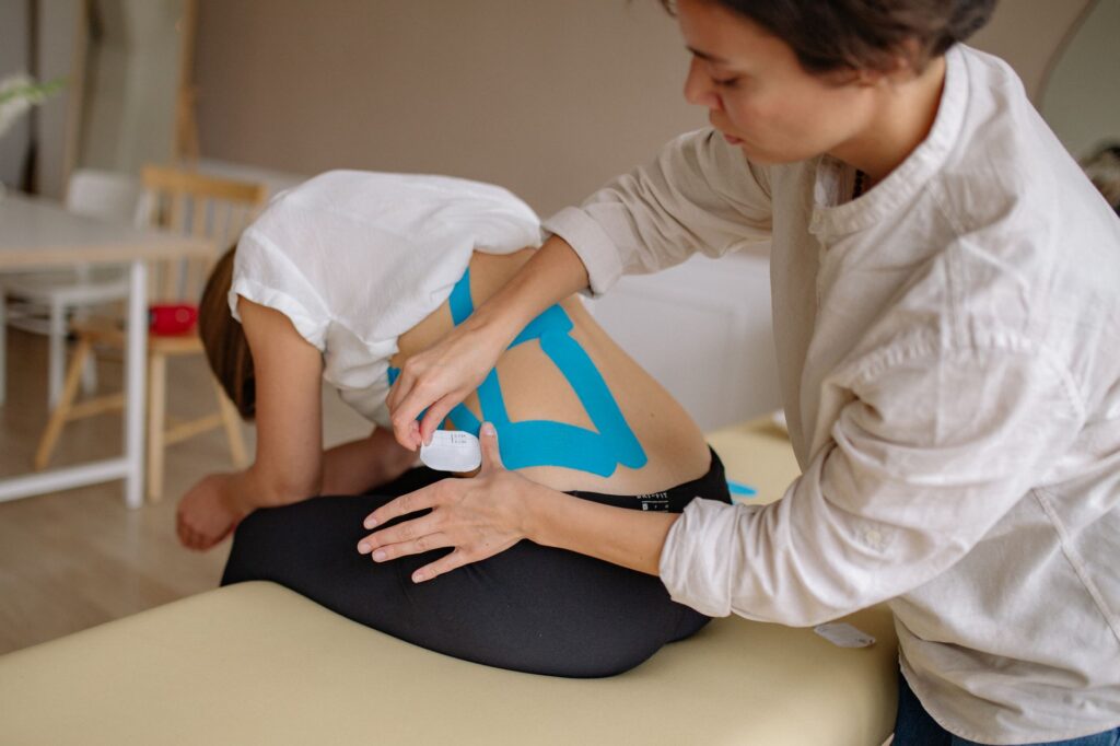 Physiotherapist treating patient lower back during rehabilitation session